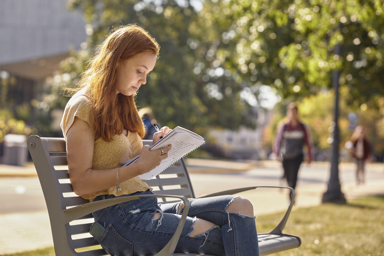 一位<a href='http://velo.ngskmc-eis.net'>全球十大赌钱排行app</a>学院的学生在校园里的长椅上读书.